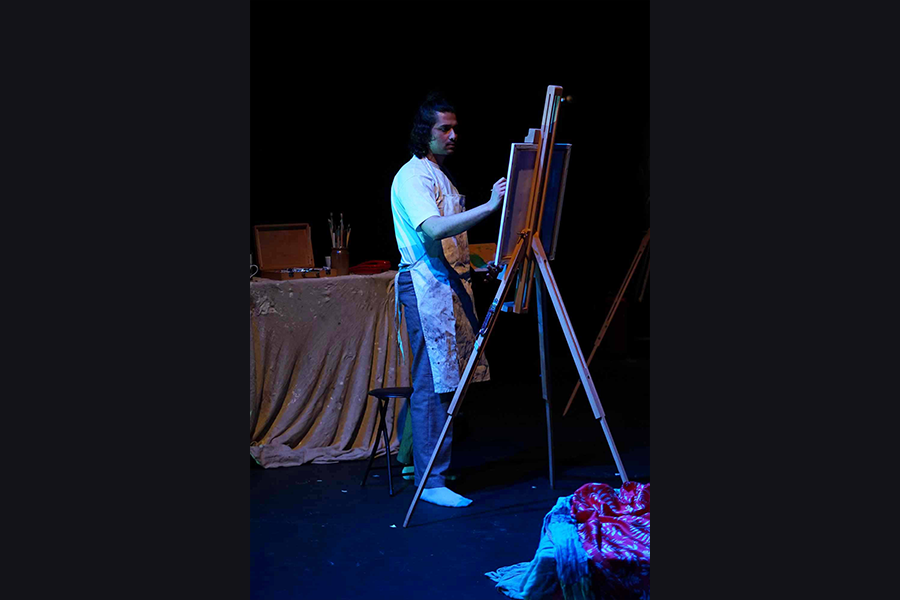 A male artist painting at his easel