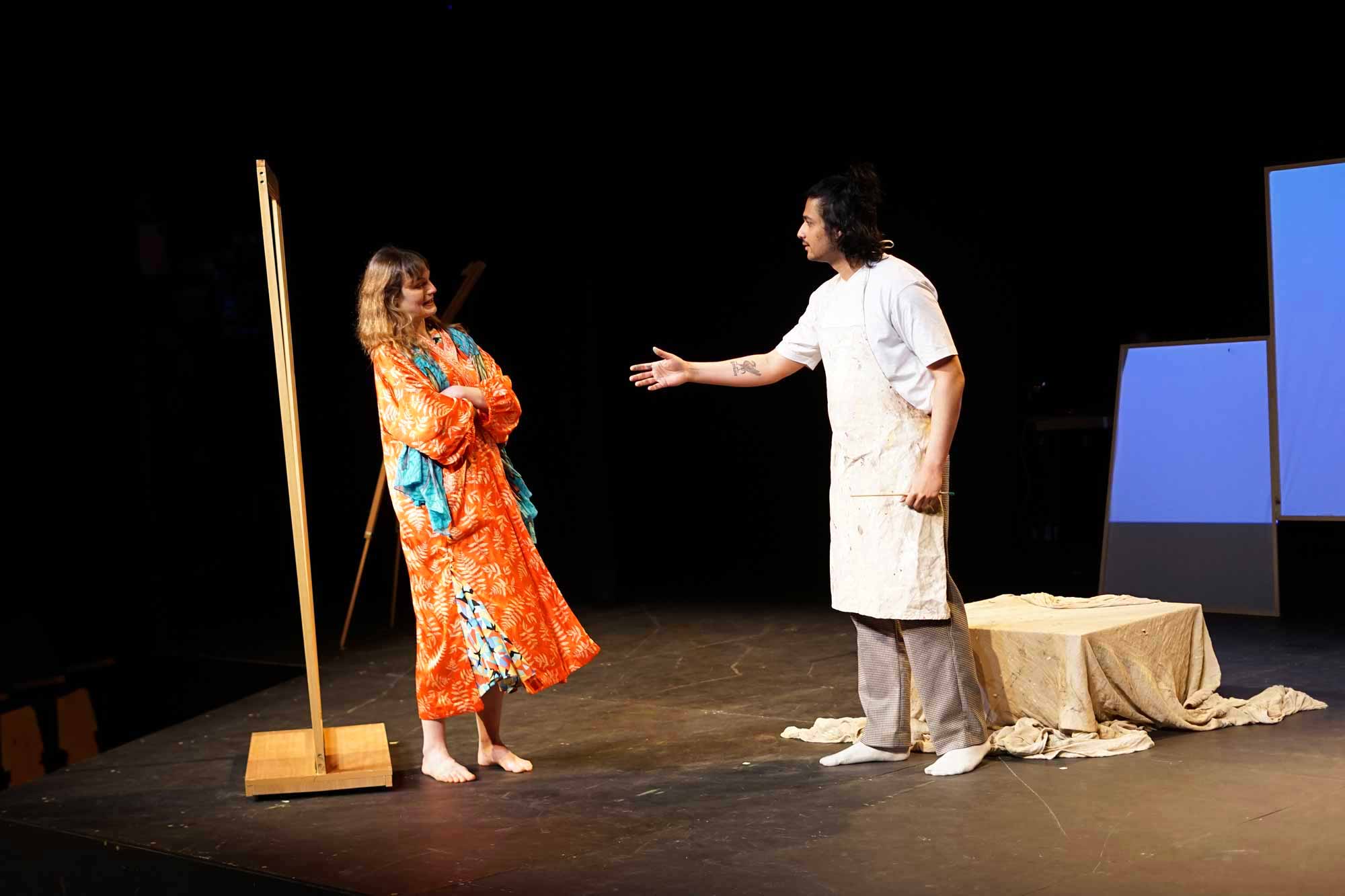 The male artist reaches out his hand towards a woman in a Japanese satin robe who is holding her arms crossed