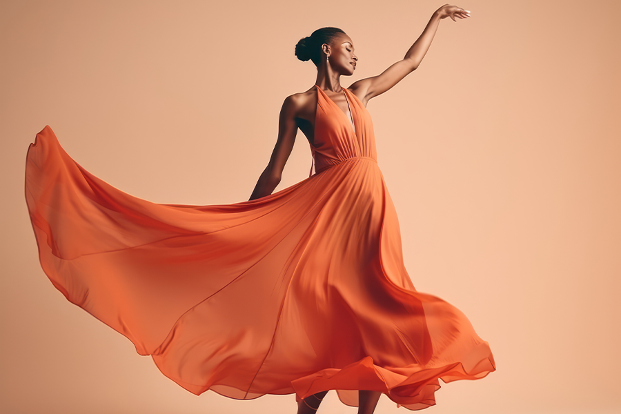 A black woman dancing in a burnt orange dress