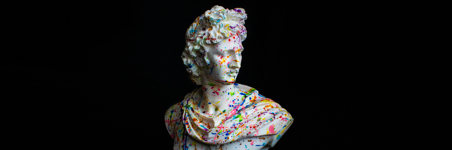 A white marble bust statue splattered in colourful paint