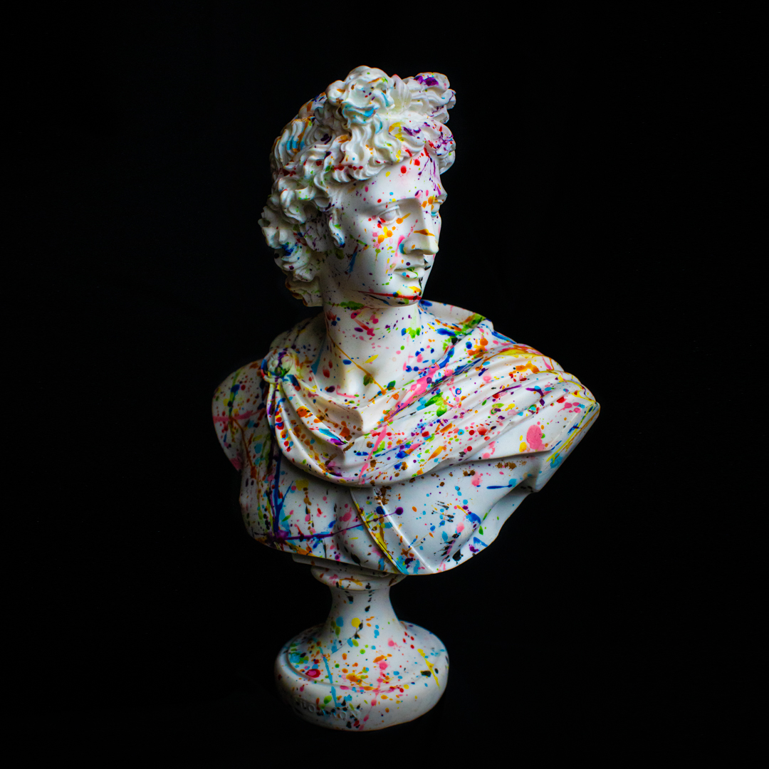 A white marble bust statue splattered in colourful paint