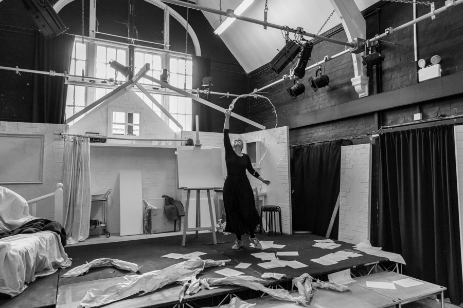 In the rehearsal room, an actor dances and liquid is held mid air