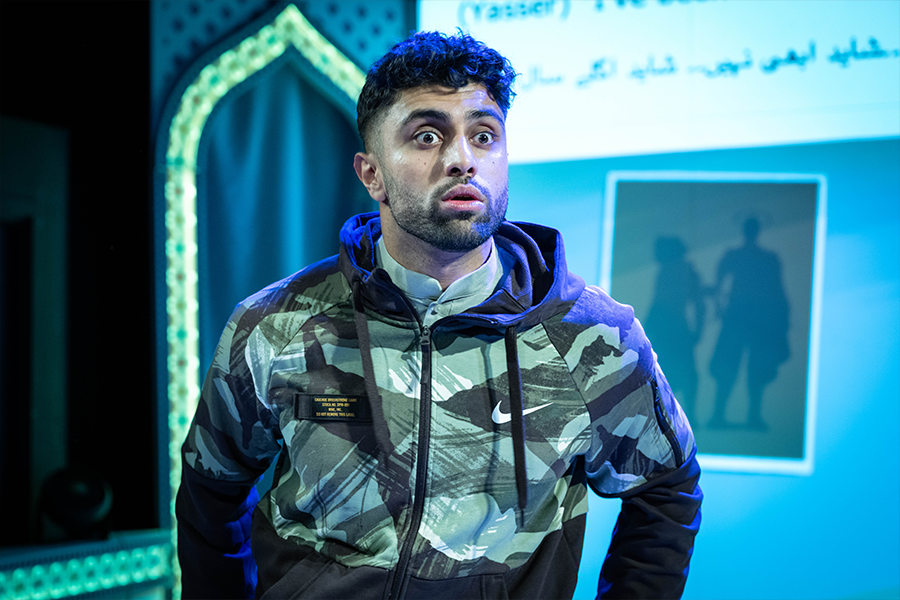 Azan Ahmed, a young south asian man, wears a nike camouflage hoodie and looks surprised.